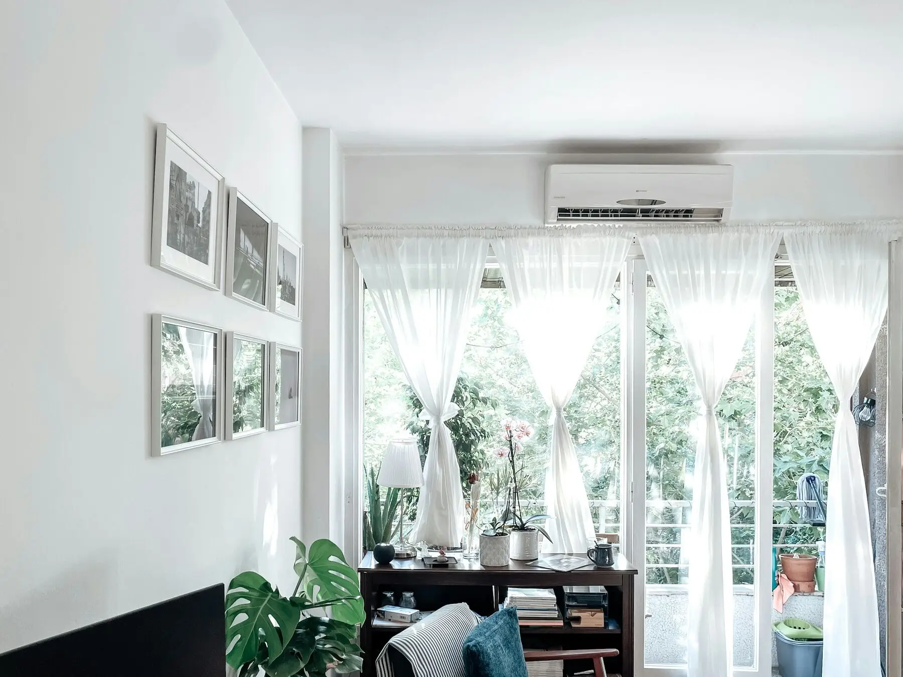 Lichte woonkamer met een airco boven de tuindeuren